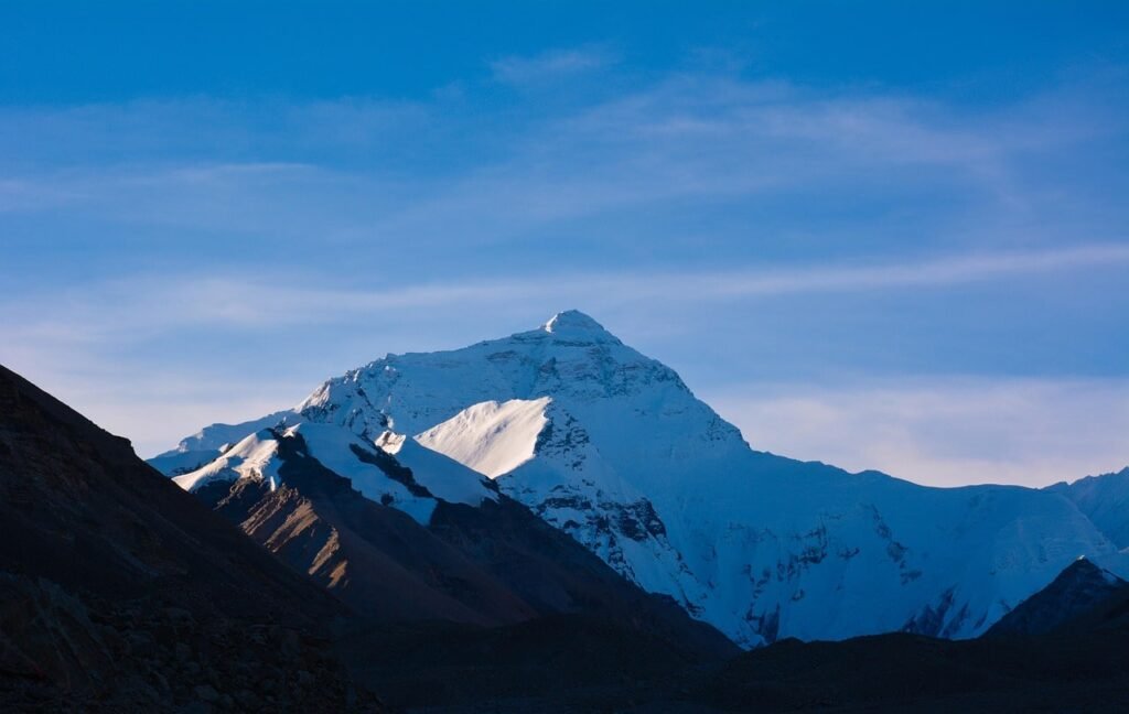 Mount Everest in the distance, surrounded by towering peaks and glaciers, as seen from the trekking trail.