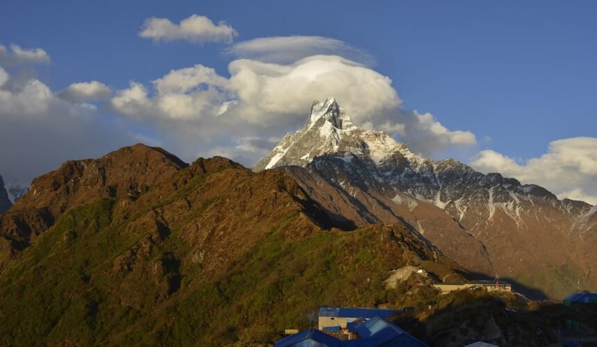 A breathtaking view of Machapuchare Mountain with its distinctive fishtail peak, seen during the Annapurna Base Camp Trek under clear blue skies.