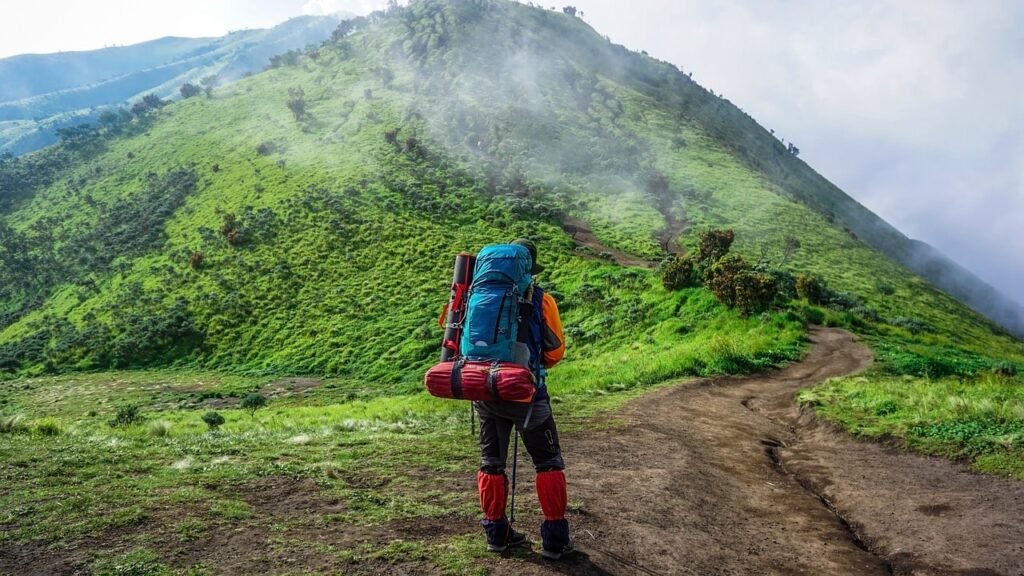 A lone trekker stands in awe, soaking in the lush green hills of Nepal during the monsoon season—where nature breathes life into every step.